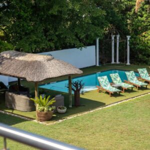 Lagoon Point Lodge: a group of chairs and an umbrella next to a pool