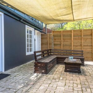 Lagoon View Accommodation: a wooden bench sitting on a patio next to a building
