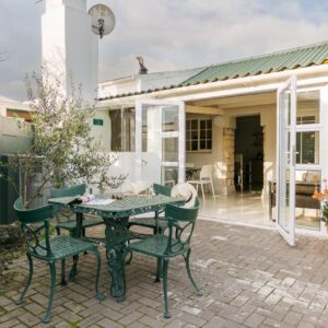 Langebaan Kite Cottages: a patio with a table and chairs in front of a house