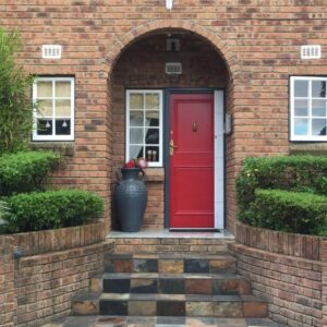 Leeuwenhof Guesthouse: a red door on a brick house with a vase