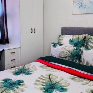 Leisure Lodges selfcatering accommodation Parow: a bedroom with a bed and a desk with a computer
