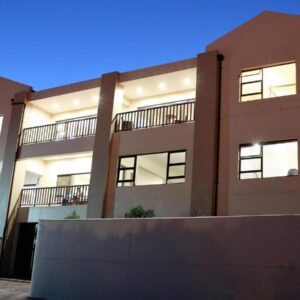 LêPlek Guesthouse: a large brick building with lights on at L\u00eaPlek Guesthouse in Saldanha