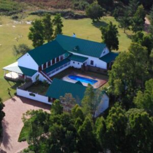 L'Heritage Retreat: an aerial view of a large white house with a green roof