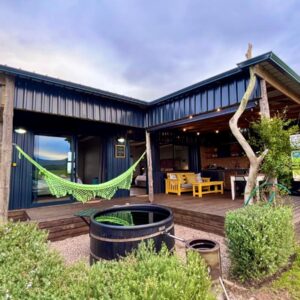 Libertas Guest Farm: a house with a hammock in front of it