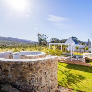 Lucky Crane Villas: a stone wall in the yard of a house with a hot tub