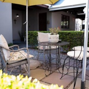 Mabet & Gabriella Guest Rooms: a patio with a table and chairs and an umbrella