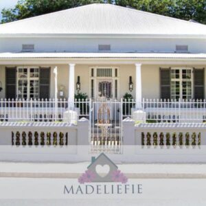 Madeliefie Guest Accommodation: a white house with a white picket fence