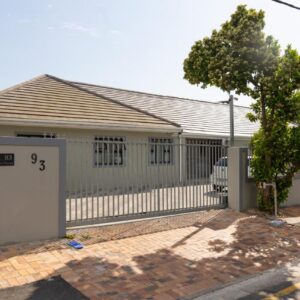 Malaika Guest House: a house with a white fence and a gate