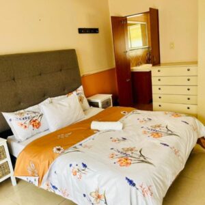 Mestil Guesthouse: a bedroom with a bed with a floweridered comforter