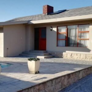 Mila's at Panorama: a house with a swimming pool in front of it