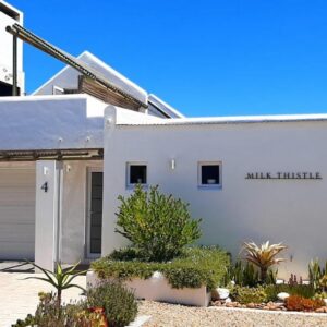 Milk Thistle Loft & Studio apartments: a white house with a garage in front of it