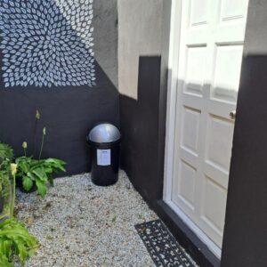 Milky Way: a white door and a trash can next to a building
