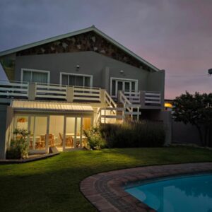 Moments Guesthouse, Kleinmond: a house with a swimming pool in front of it