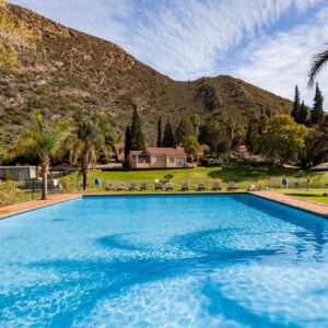 Montagu Springs Resort: a large blue swimming pool in front of a mountain