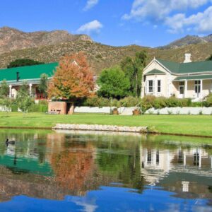 Montagu Vines Guesthouse: a house next to a lake with mountains in the background