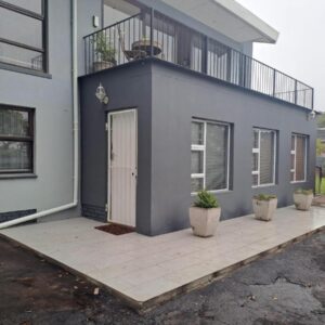 Mooiloop Self Catering: a blue house with two potted plants in front of it