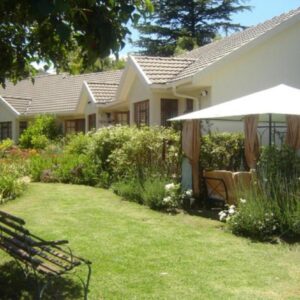 Mooring House: a white house with an umbrella and a yard