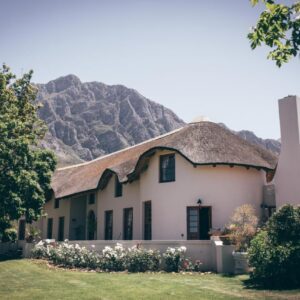 Mountain Manor: a house with a thatched roof with mountains in the background