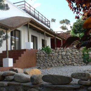 Mountain View Eco Lodge Montagu: a house with a stone wall in front of it