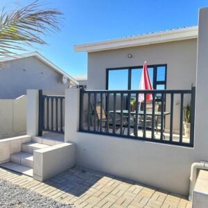 Mountain View Guesthouse: a house with a palm tree next to a fence