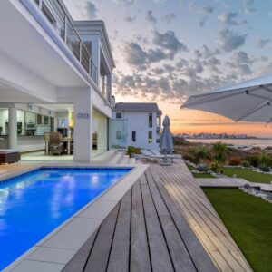 Musselcracker bed and breakfast: a house with a swimming pool and an umbrella