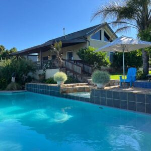 Narnia Guest House: a swimming pool in front of a house