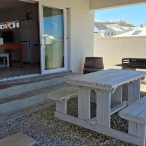 Nautilus Self Catering: a picnic table and a bench outside of a house