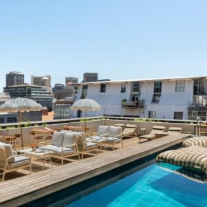 Neighbourgood 84 Harrington: a rooftop pool with chairs and tables on a building