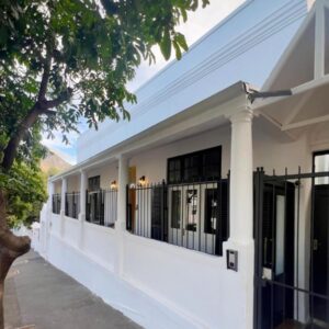 Nomad City Suites: a white building with a fence on a street