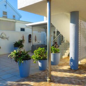On The Beach Apartments: a patio with potted plants on a house