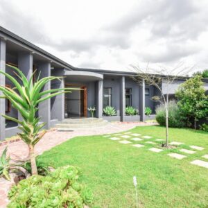 OnQ Accommodation: an exterior view of a house with a yard