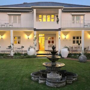 Oude Berg Guesthouse: a large white house with a fountain in the yard