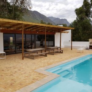 Oudekloof Wine Estate: a patio with a swimming pool and a house