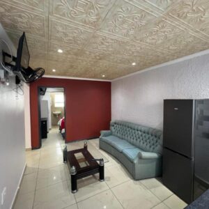 Our Home Guest House: a living room with a couch and a table