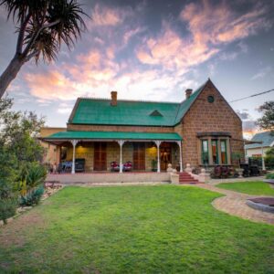 Outentique Accommodation: a house with a green roof and a yard