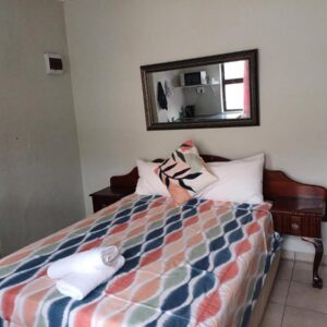 Overnight Lodge: a bedroom with a bed with a mirror on the wall