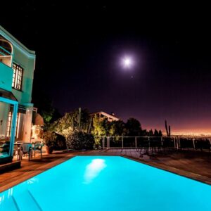 Panorama Guest House: a swimming pool in front of a house at night
