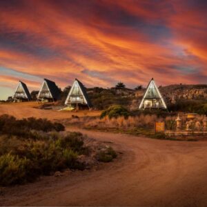 Peace Haven @ Windfarm Accommodation: a dirt road with a group of triangular buildings on a hill
