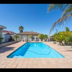 Peters Place: a large blue swimming pool in front of a house