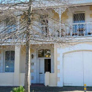 Petites Bulles Lodge: a white house with a white garage door and a tree