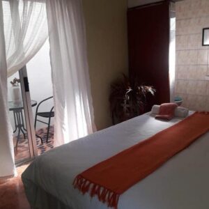 Phofolo Guest House: a bedroom with a large bed and a balcony