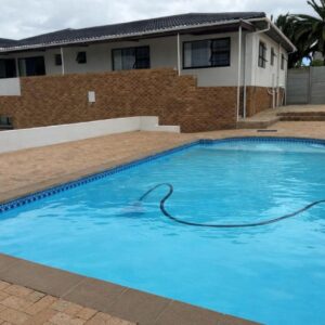 Plattekloof guest house: a large blue swimming pool in front of a house