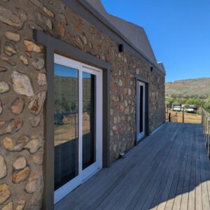 Potjesberg Lodge: a wooden deck next to a stone building