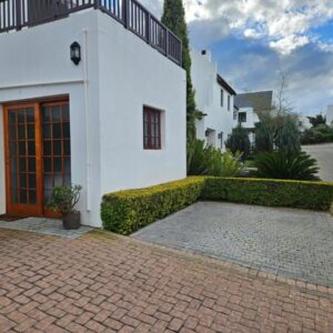 Protea Rus: a white house with a red door and a brick driveway