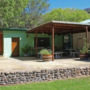 Rainbow Glen Self Catering Chalets: a house with a stone wall and a patio