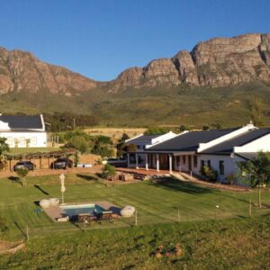Raptor Rise Farm: an aerial view of a house with mountains in the background
