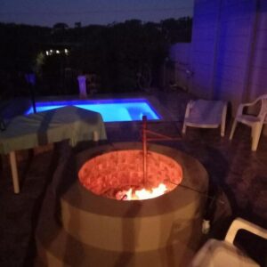 Revive Guesthouse: a fire pit in front of a pool at night