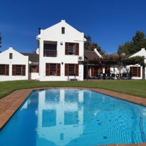 Rhodene Farm Cottages: a house with a swimming pool in front of a house