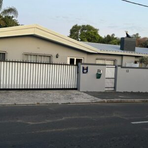 Ridah's Accomodation: a white house with a fence and a street