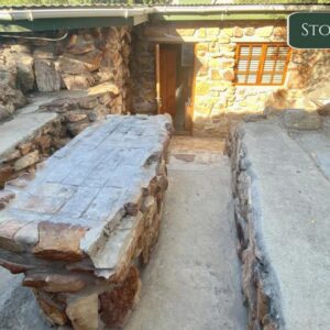 Rondeberg Holiday Resort: a stone building with a wooden bench in front of it